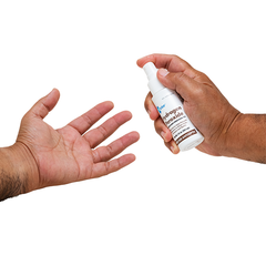 A hand sprays Globe Hydrogen Peroxide 3% First Aid Antiseptic Topical Solution USP from a 2 fl. oz pump spray bottle onto another’s open palm, ideal for cleaning minor cuts, set against a white background.