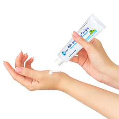 A person squeezes Globe Anti-Itch Cream with Histamine Blocker (Compare to BENADRYL) 1.5 oz Tube onto the back of their other hand against a white background for poison ivy relief.