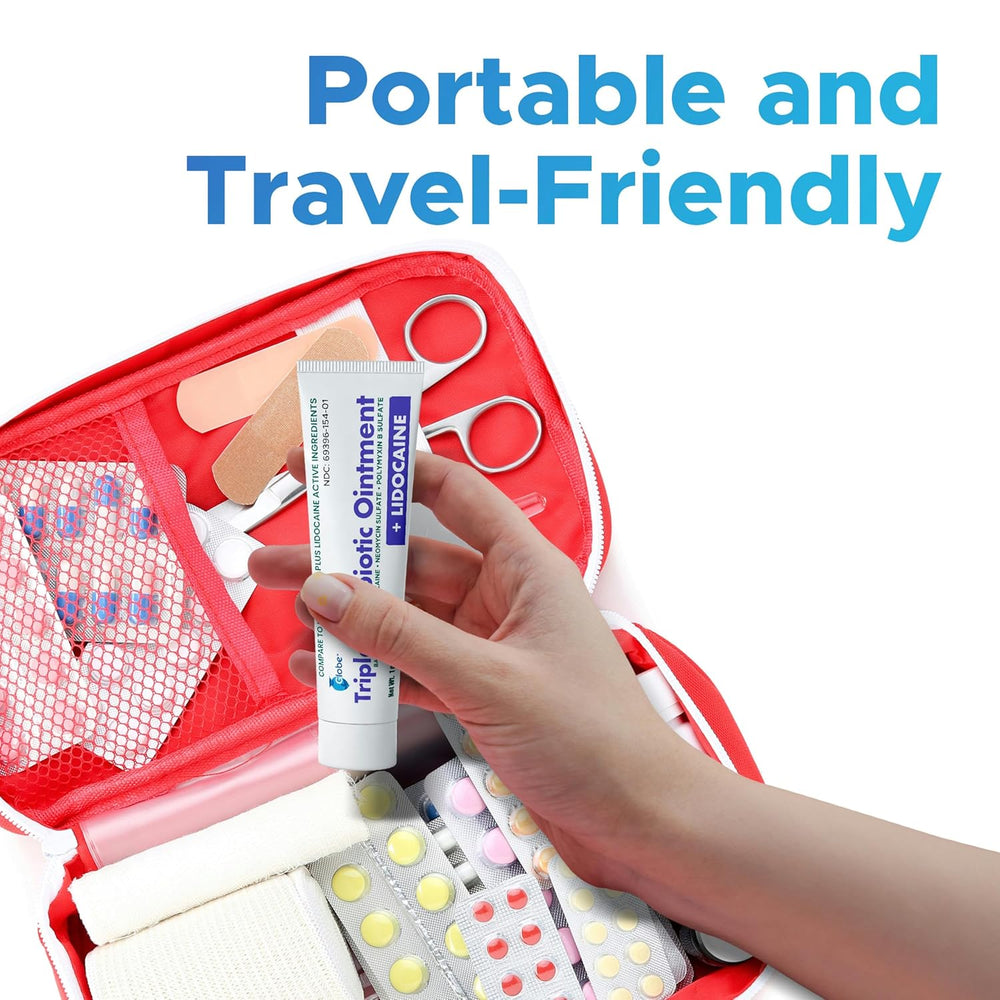 A hand holds Globe First Aid Antibiotic Ointment + Lidocaine 1 Oz above an open red first aid kit with bandages, pills, and supplies. Text reads: Portable and travel-friendly—ideal for fast pain relief & wound care on the go.