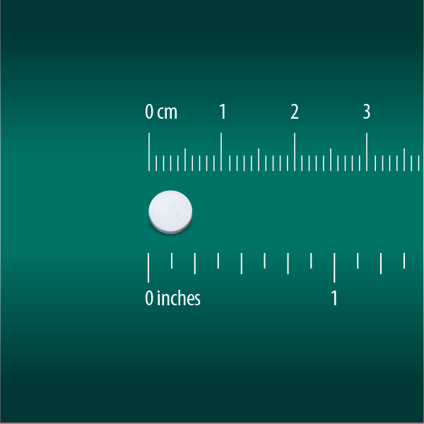 A Globe Chewable Mint Antacid Tablet for acid indigestion, heartburn, and upset stomach sits on a green background beside a ruler in inches and centimeters; the small white round pill measures just under 1 centimeter wide.