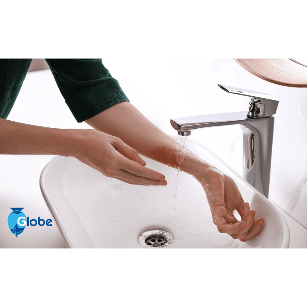 A person rinses a burn on their forearm under running water in a white sink. After rinsing, Globe First Aid Burn Gel with Aloe 0.9g packets (Box of 144) may be applied for temporary relief of minor burns, cuts, and scrapes. Globe logo is shown.