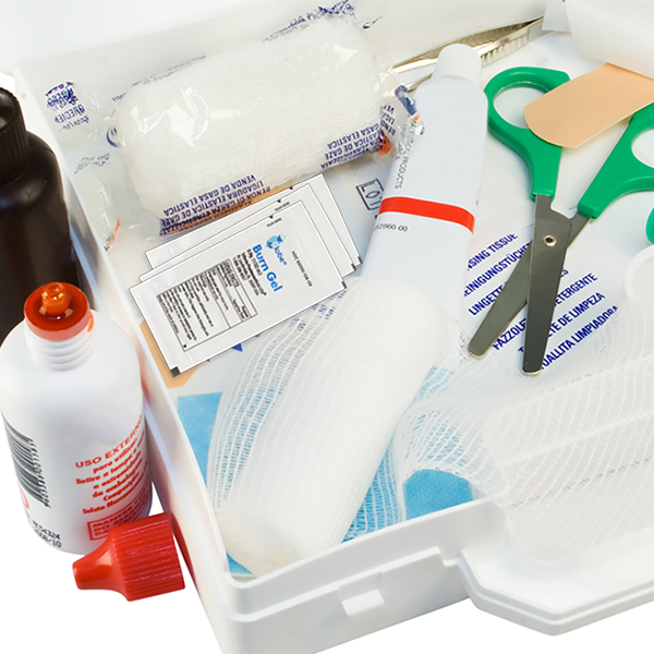 A close-up of an open first aid kit containing Globe First Aid Burn Gel with Aloe 0.9g packets (box of 144) by Globe, along with bandages, gauze rolls, scissors, antiseptic wipes, adhesive bandages, and medicine bottles with red caps.
