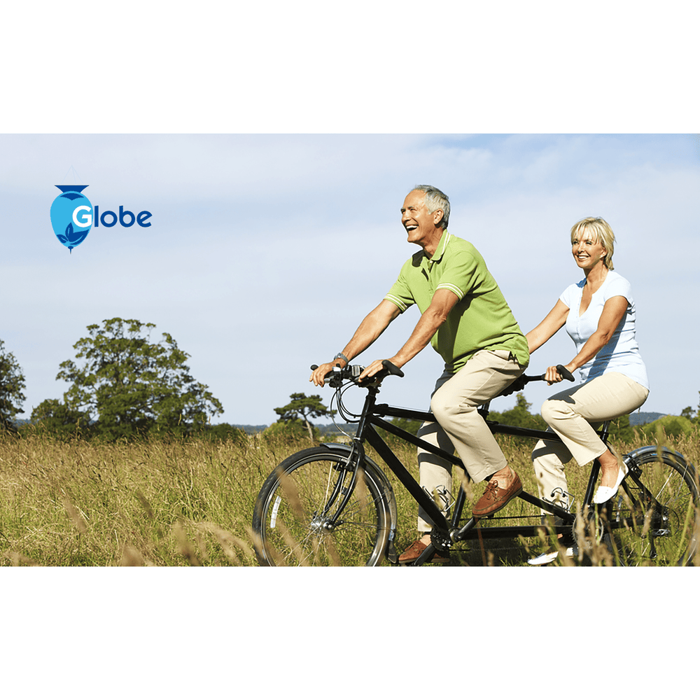 A smiling older couple rides a tandem bike through a sunny field. The Globe logo in the corner highlights Globe Dibucaine 1% Hemorrhoid Treatment Ointment—rapid numbing relief for pain, itch, and burn, so you enjoy comfortable outdoor adventures.