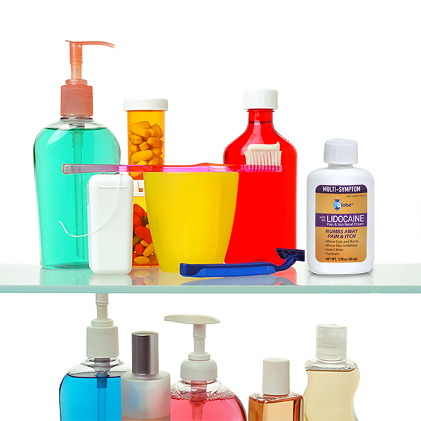 A bathroom shelf holds pills, mouthwash, a yellow cup with a pink toothbrush, razor, red bottle, and Globe Lidocaine 4% Multi-Symptom Relief Cream for pain and itch relief. Hand soap and other toiletries are on the lower shelf.