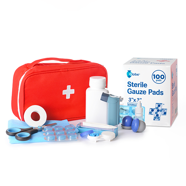 A red first aid kit bag with a white cross is surrounded by medical items, including Globe 3’’ x 3’’ Advanced Sterile Gauze Pads for Wound Dressing (100-pack), a pill organizer, tape, scissors, tweezers, and small medicine containers.