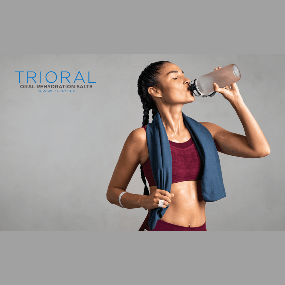 A fit woman in workout clothes drinks from a bottle with a towel around her neck. The text “TRIORAL Rehydration Electrolyte Powder—WHO Hydration Supplement Salts Formula” highlights this 50-pack rehydration drink.