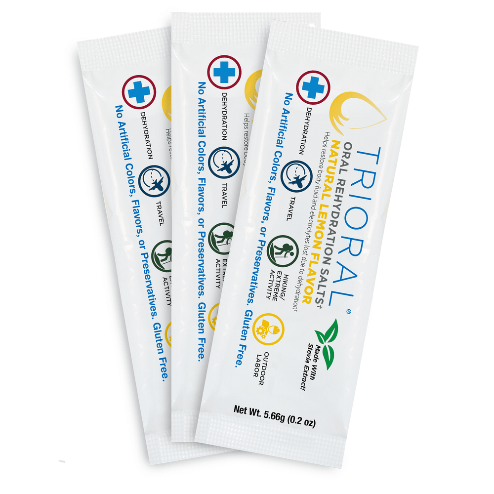 Three TRIORAL Natural Lemon w/ Stevia Oral Rehydration Salts packets (WHO New Formula, 25/Box) are fanned out, showcasing gluten-free, preservative-free dehydration relief—ideal for travel, sports, and outdoor activities.